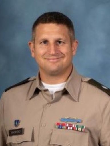 A white man with brown hair wearing a tan Army uniform